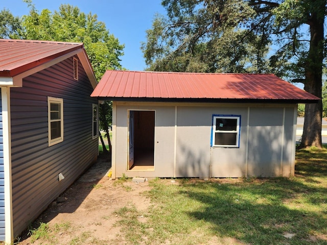 rear view of house featuring an outbuilding and a yard