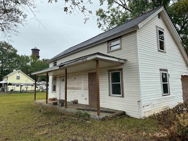 rear view of house featuring a yard