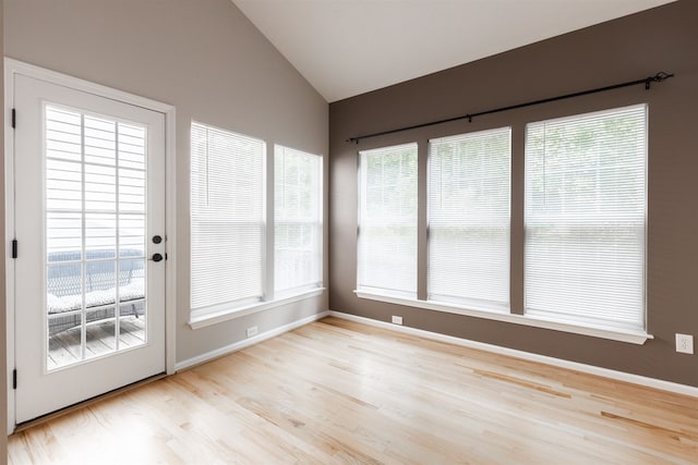 unfurnished sunroom featuring vaulted ceiling