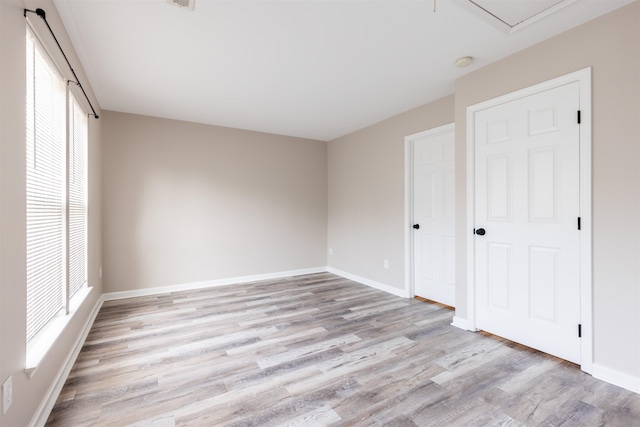 unfurnished room featuring light wood-type flooring and a healthy amount of sunlight