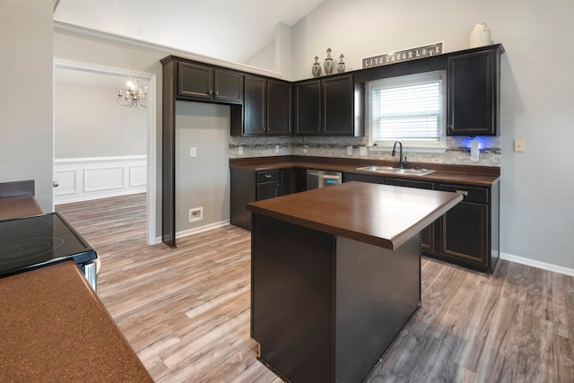 kitchen with backsplash, light hardwood / wood-style flooring, range with electric cooktop, sink, and a chandelier