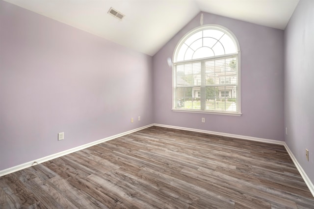 spare room with lofted ceiling and dark wood-type flooring