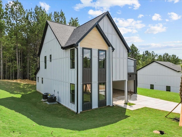 view of outdoor structure with a lawn and central AC