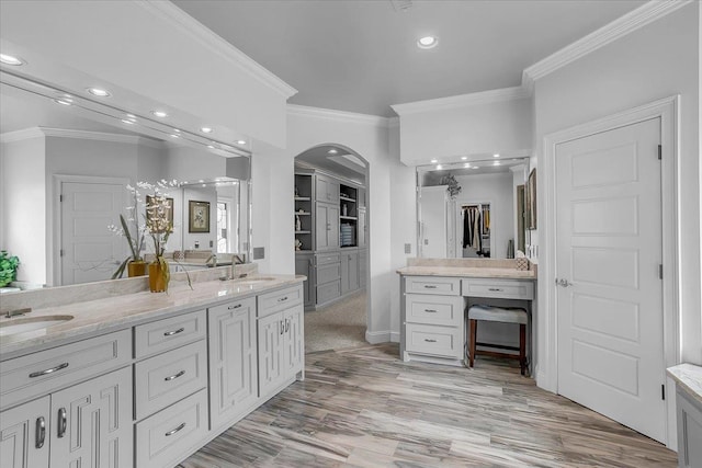 full bath featuring a sink, crown molding, recessed lighting, double vanity, and wood finished floors