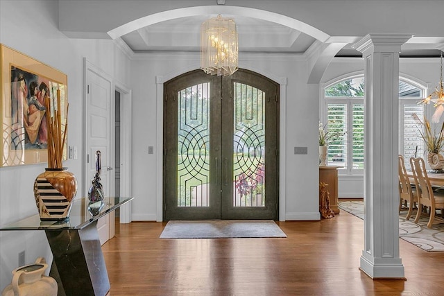 entrance foyer with french doors, arched walkways, an inviting chandelier, and wood finished floors