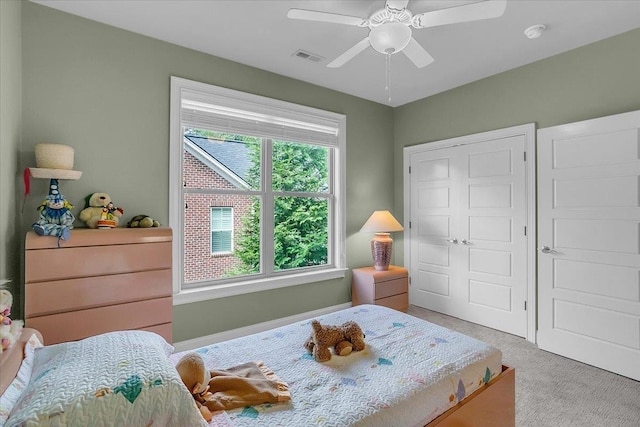 carpeted bedroom with a closet, ceiling fan, and visible vents