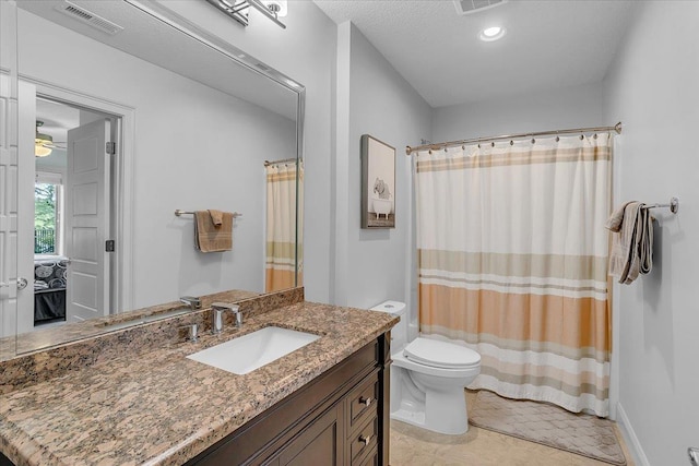 full bath featuring vanity, curtained shower, a ceiling fan, toilet, and visible vents