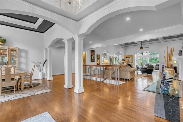interior space with decorative columns, a ceiling fan, ornamental molding, and wood finished floors