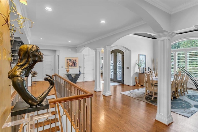 foyer entrance with ornamental molding, recessed lighting, ornate columns, arched walkways, and wood finished floors