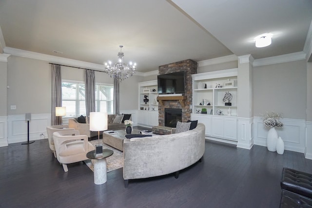 living room with crown molding, a fireplace, dark hardwood / wood-style floors, and a notable chandelier