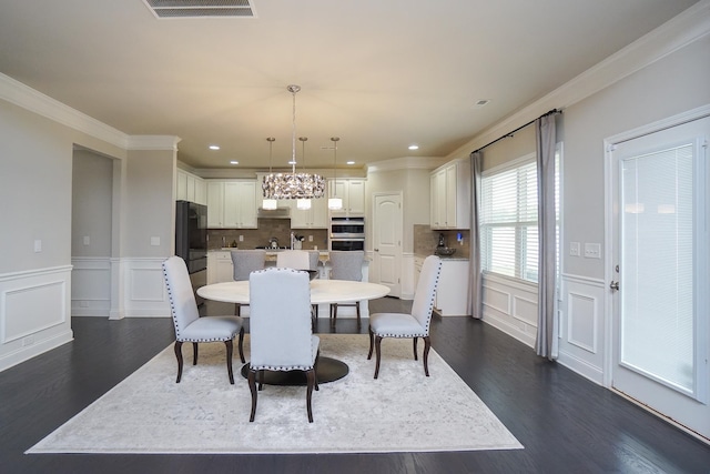 dining space featuring an inviting chandelier, crown molding, and dark wood-type flooring