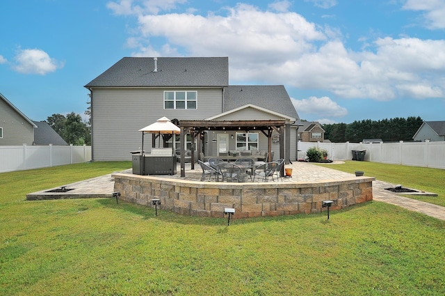 rear view of property featuring a lawn, a patio area, a gazebo, and a fire pit