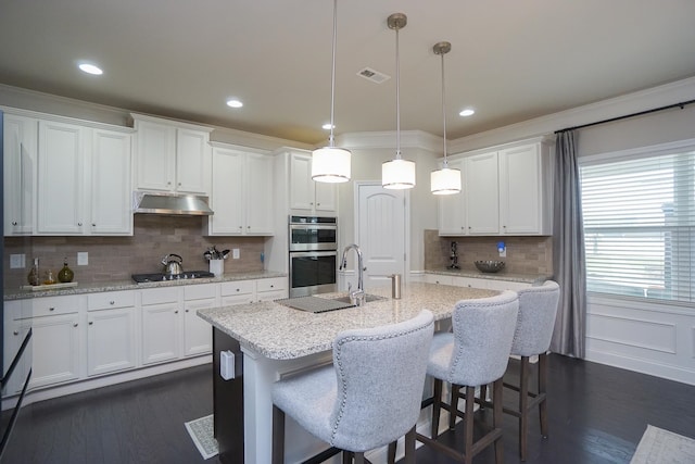 kitchen featuring white cabinetry, stainless steel double oven, and hanging light fixtures