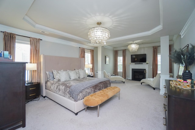 carpeted bedroom featuring multiple windows, crown molding, a tray ceiling, and a notable chandelier