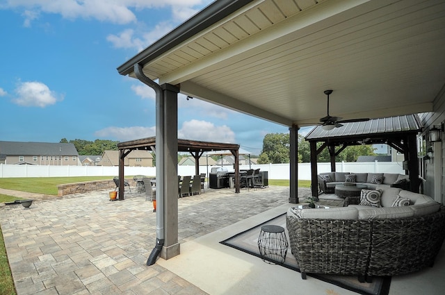 view of patio / terrace with ceiling fan, an outdoor living space, and a gazebo