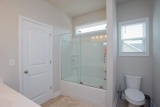 full bathroom featuring bath / shower combo with glass door, tile patterned floors, toilet, and a healthy amount of sunlight