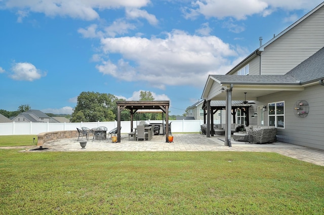 view of yard featuring a fire pit, ceiling fan, and a patio area