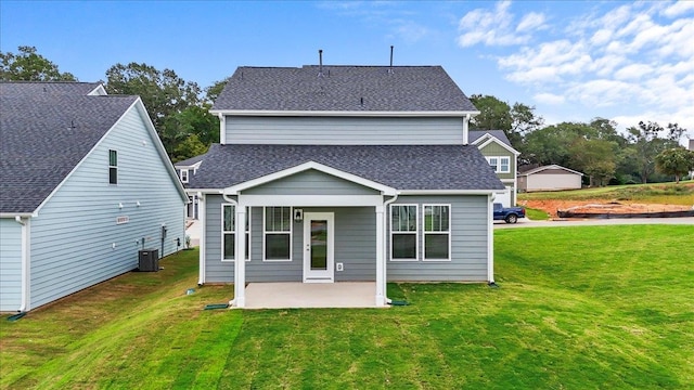 rear view of house with central AC unit, a patio area, and a yard