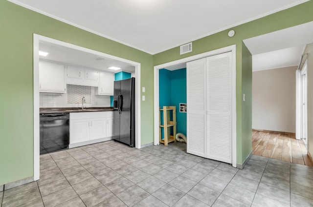 kitchen with crown molding, white cabinetry, decorative backsplash, and black appliances