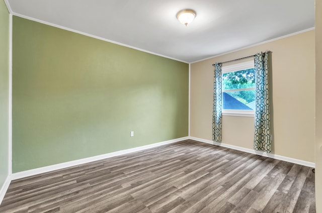 empty room featuring ornamental molding and wood-type flooring