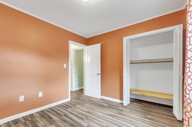 unfurnished bedroom featuring light hardwood / wood-style flooring, a closet, and ornamental molding