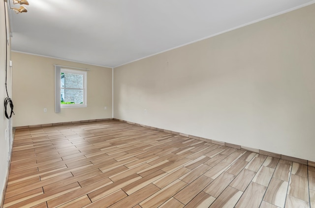 spare room featuring light hardwood / wood-style flooring and crown molding