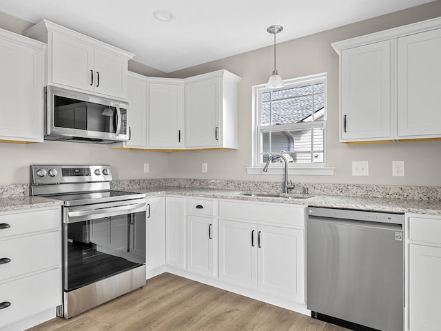 kitchen with light hardwood / wood-style flooring, stainless steel appliances, white cabinets, and sink