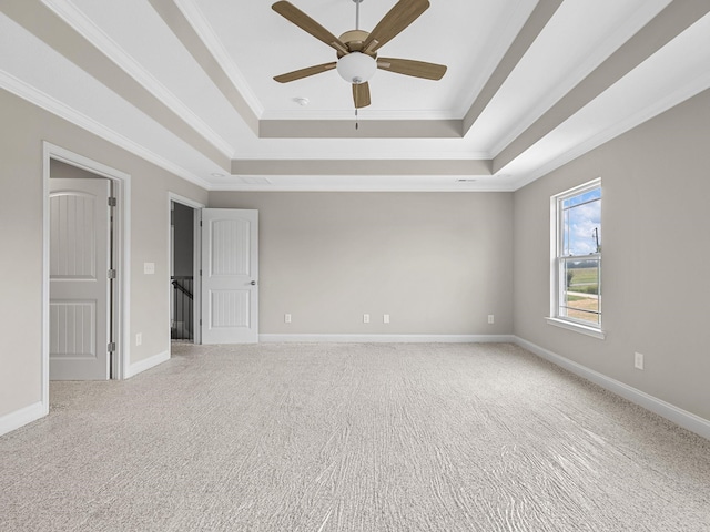 unfurnished room with crown molding, carpet, a tray ceiling, and ceiling fan