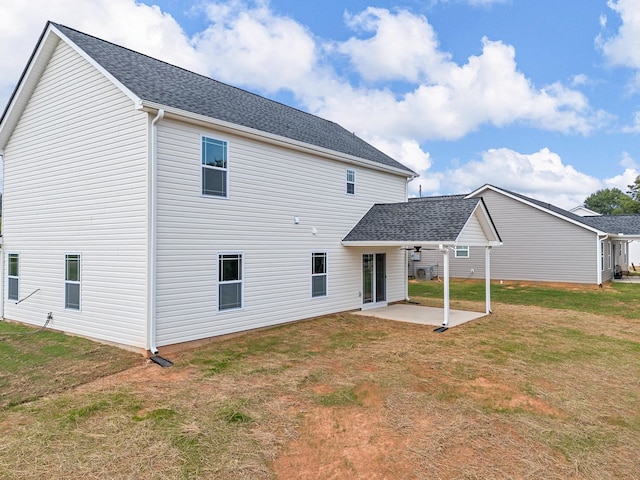 rear view of property featuring a lawn and a patio area