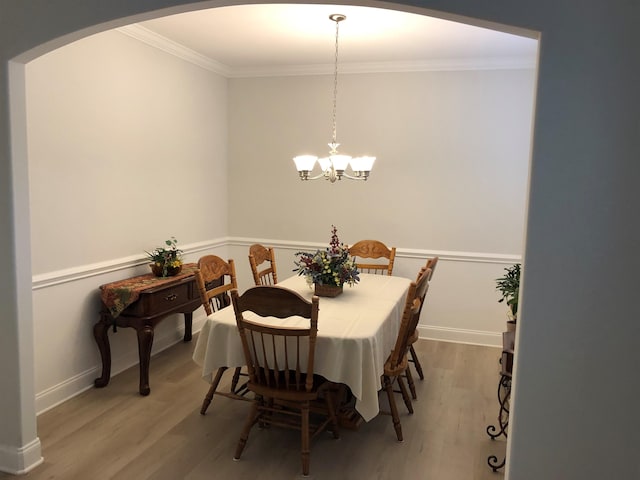 dining space featuring ornamental molding, a chandelier, and hardwood / wood-style floors