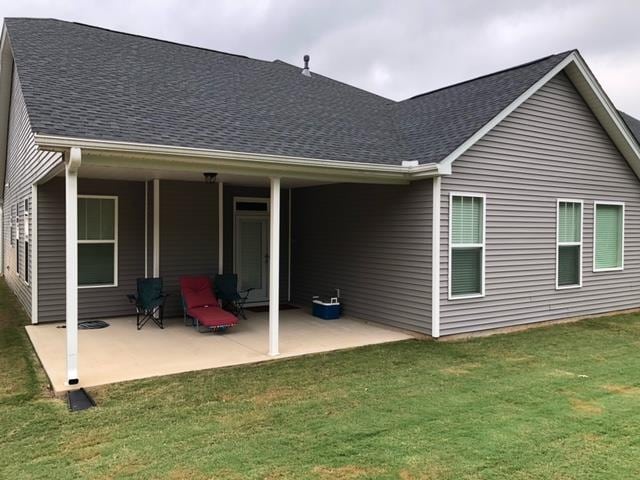 back of house featuring a lawn and a patio area