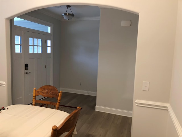 foyer with ornamental molding and dark hardwood / wood-style flooring