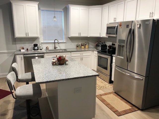 kitchen featuring stainless steel appliances, sink, white cabinetry, and decorative backsplash