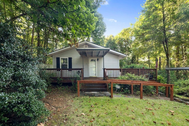 back of property with a wooden deck and a yard