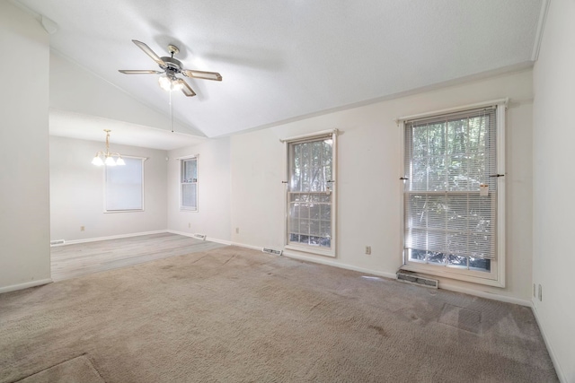 unfurnished room featuring ceiling fan with notable chandelier, lofted ceiling, and carpet