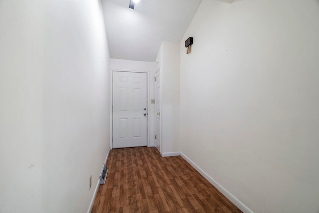 corridor with lofted ceiling and dark hardwood / wood-style flooring