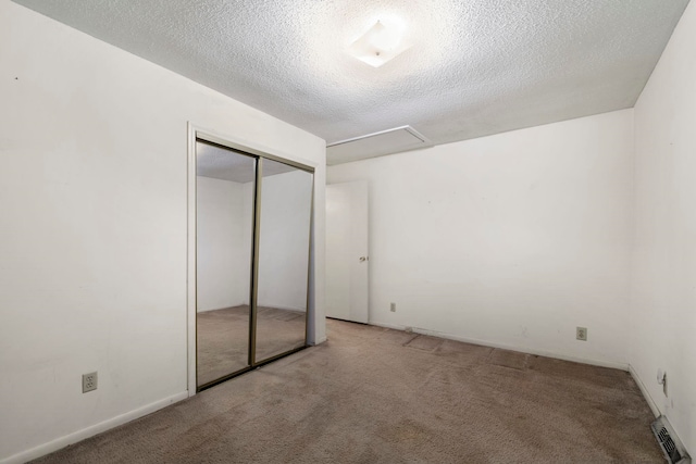 unfurnished bedroom with light colored carpet, a textured ceiling, and a closet