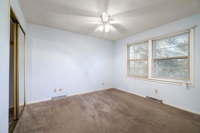 unfurnished bedroom featuring a textured ceiling, carpet flooring, ceiling fan, and a closet