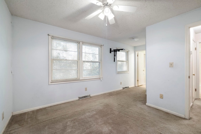 spare room with ceiling fan, light colored carpet, and a textured ceiling