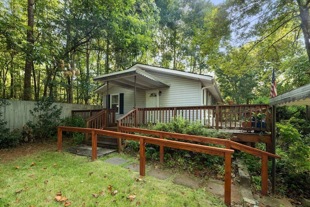 back of property with a wooden deck and a yard