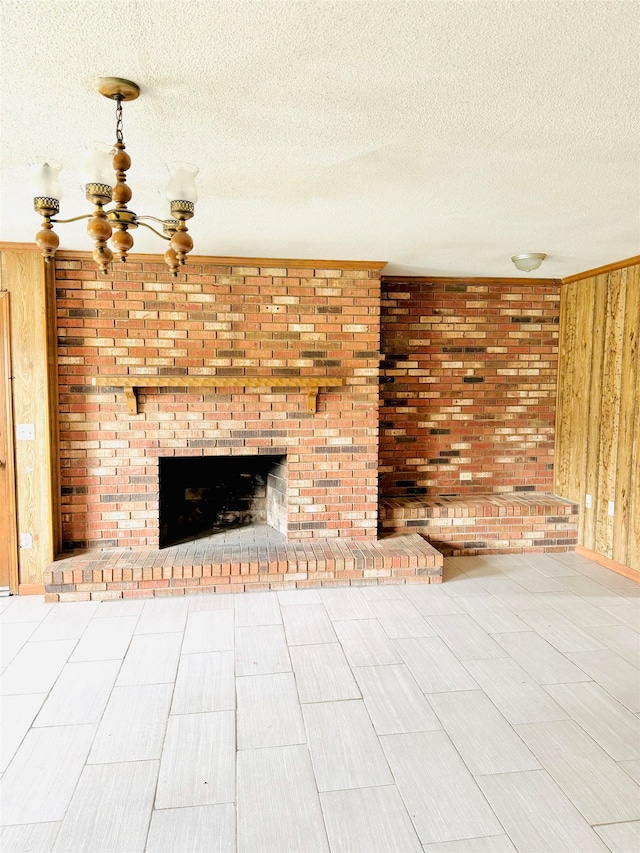 unfurnished living room with a textured ceiling, a fireplace, and a chandelier