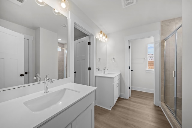 bathroom featuring hardwood / wood-style floors, walk in shower, and vanity