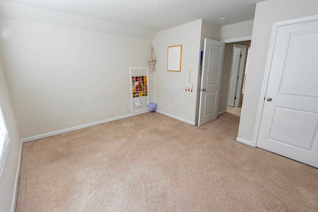 unfurnished bedroom featuring lofted ceiling and light colored carpet