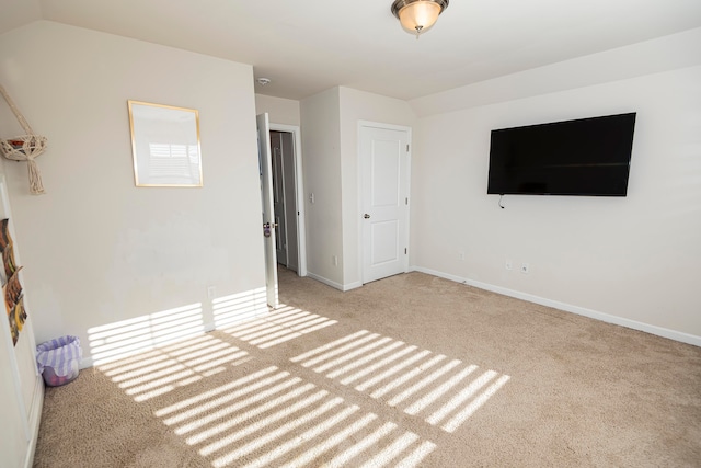 unfurnished bedroom featuring light colored carpet and vaulted ceiling