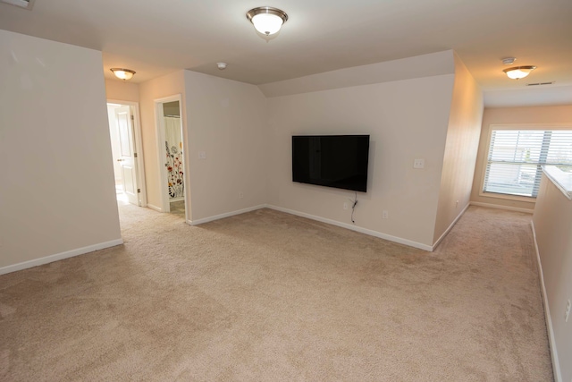 unfurnished living room with light colored carpet and vaulted ceiling