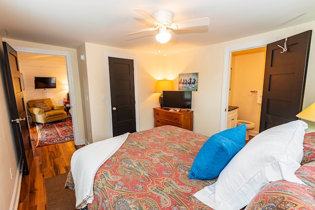 bedroom with ceiling fan, ensuite bathroom, and hardwood / wood-style flooring