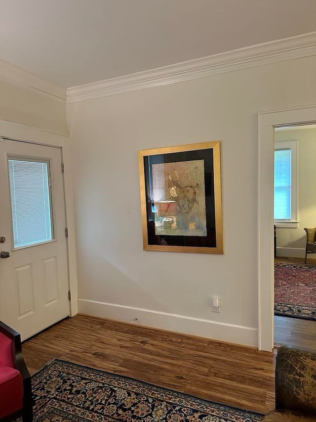 entryway with ornamental molding and hardwood / wood-style floors