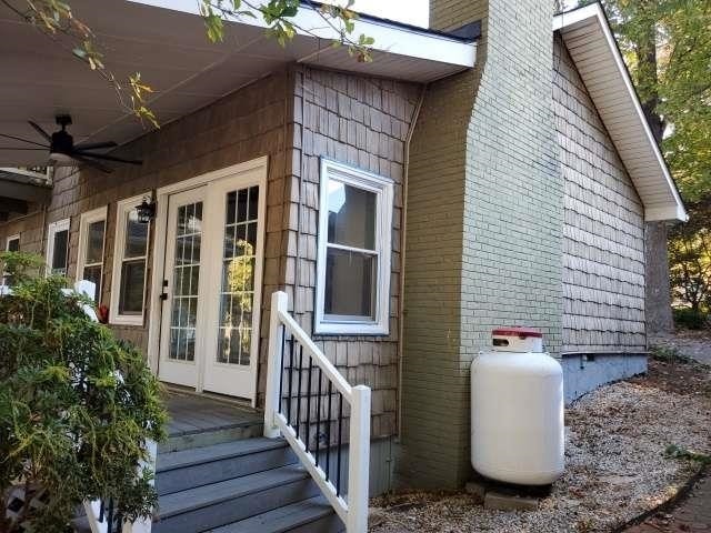 view of side of home featuring ceiling fan and french doors