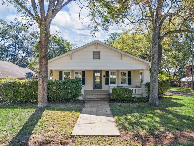 bungalow-style house featuring a front lawn and covered porch