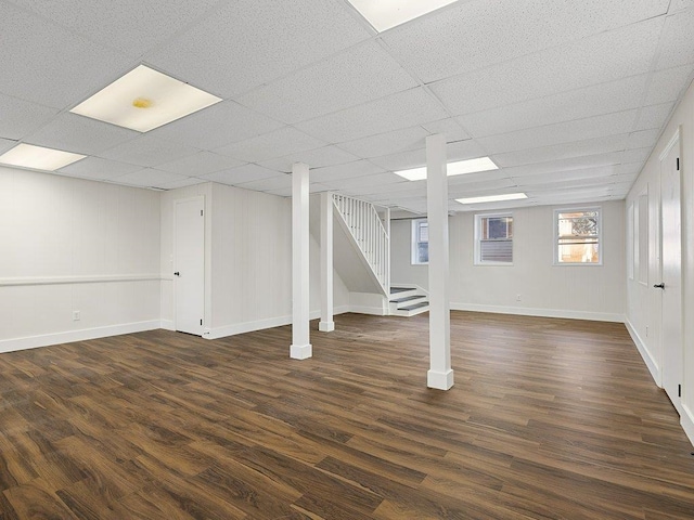 basement featuring a drop ceiling and dark hardwood / wood-style floors